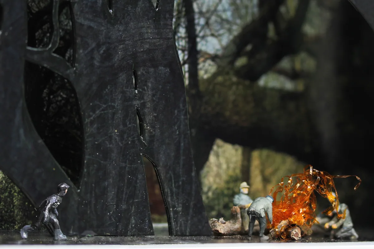 Closer detail: the figures and the glowing fire.