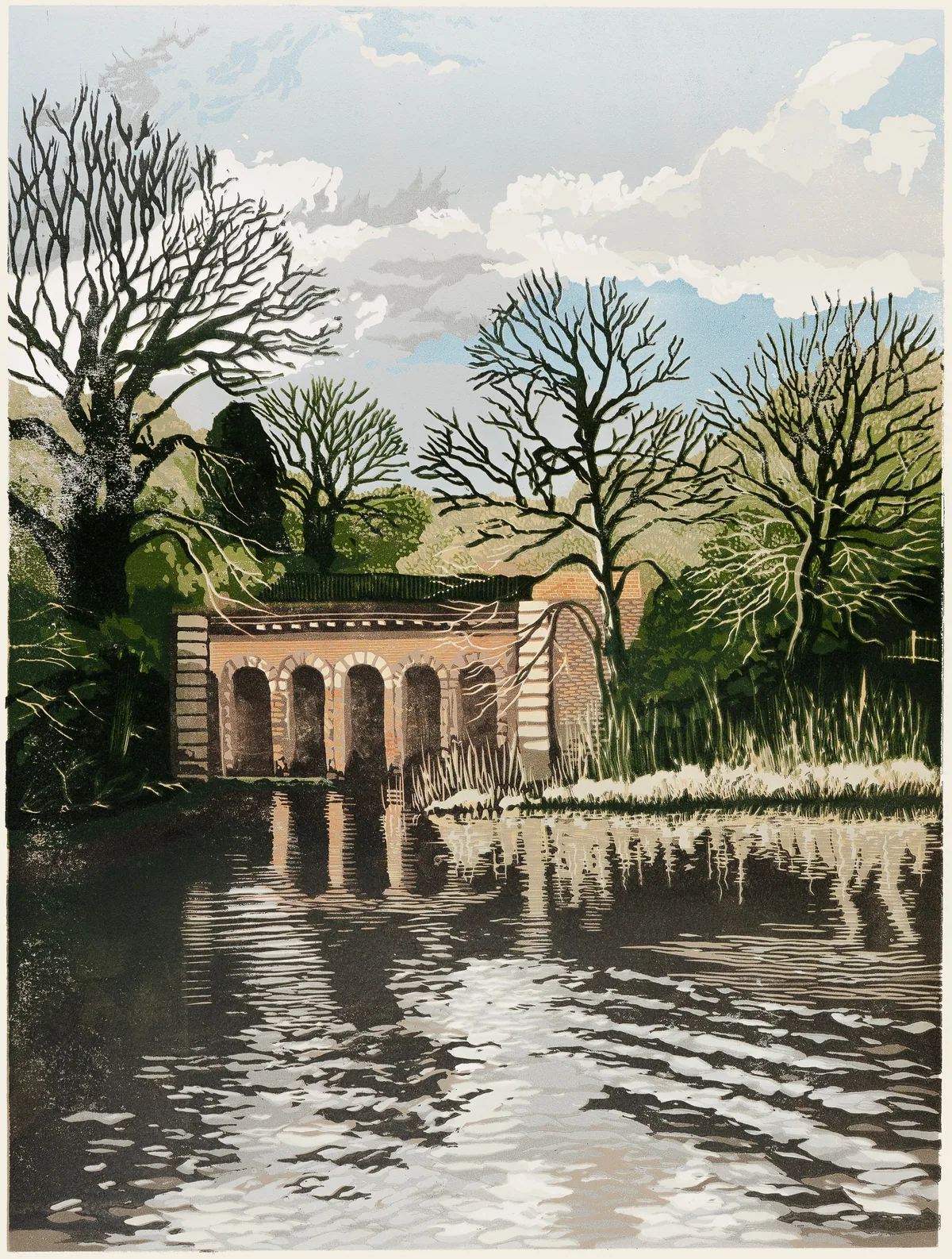 Reduction linocut of the arched brick viaduct reflected in a rippling winter pond, bare trees against a cloudy blue sky.